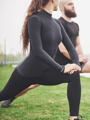 A couple stretching outdoors demonstrating RV healthy living